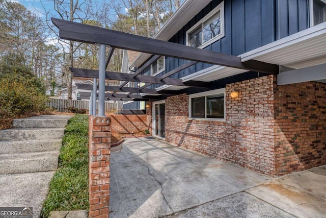 exterior space with a patio, board and batten siding, fence, and a pergola