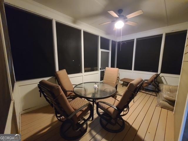 sunroom / solarium featuring a ceiling fan