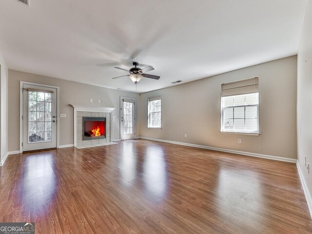 living area featuring a fireplace, wood finished floors, and baseboards