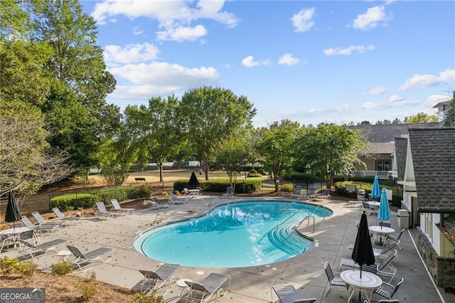 pool with fence and a patio