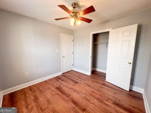 unfurnished bedroom with a closet, ceiling fan, and wood-type flooring