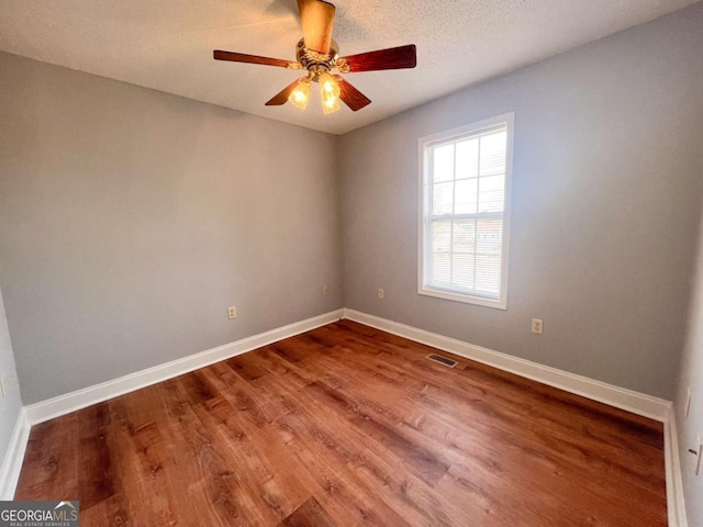 unfurnished room with a textured ceiling, hardwood / wood-style flooring, and ceiling fan