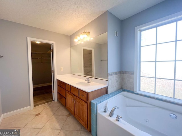 bathroom featuring vanity, tile patterned flooring, a bathtub, and a textured ceiling