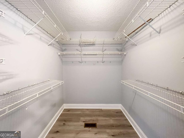 spacious closet featuring hardwood / wood-style flooring