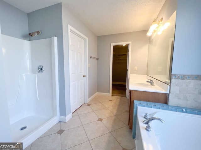 bathroom featuring a textured ceiling, vanity, shower with separate bathtub, and tile patterned floors