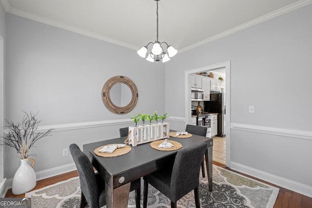 dining room with ornamental molding, baseboards, and wood finished floors