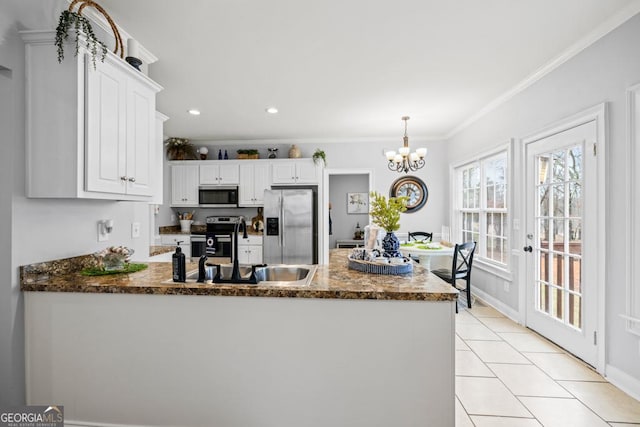 kitchen with crown molding, stainless steel appliances, white cabinets, a sink, and decorative light fixtures