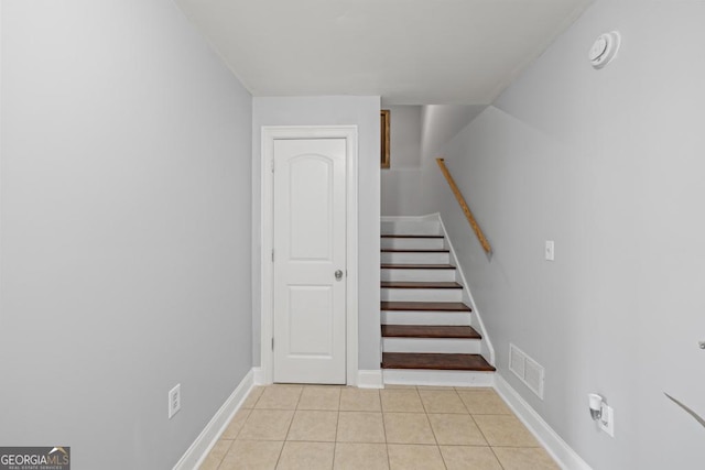 stairs featuring baseboards, visible vents, and tile patterned floors