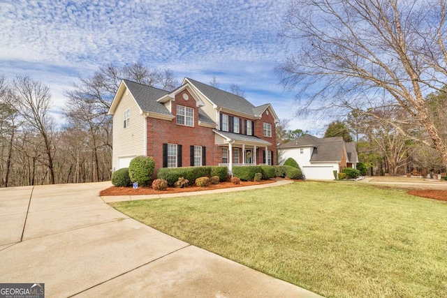 view of front of house with brick siding, a front yard, driveway, and a garage