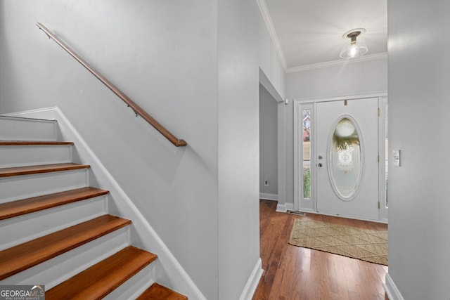 foyer entrance featuring baseboards, stairs, ornamental molding, and wood finished floors