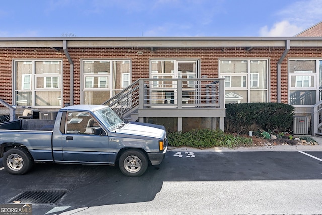 view of front of house featuring uncovered parking and brick siding