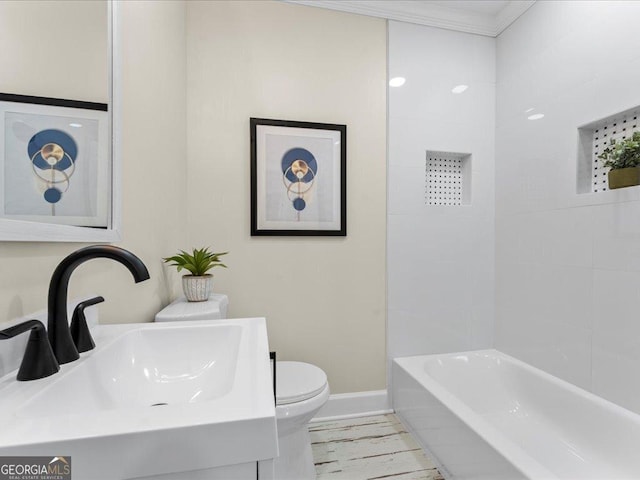 full bathroom with sink, ornamental molding, toilet, and tiled shower / bath