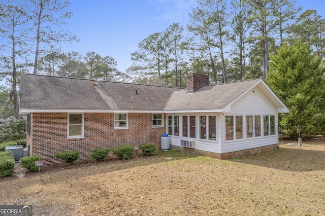 rear view of property with a yard and a sunroom