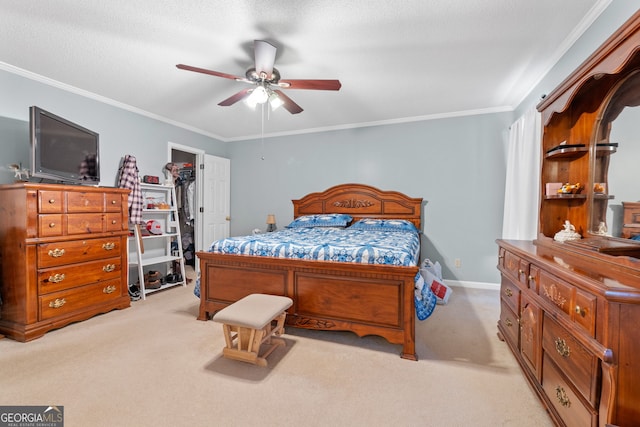 carpeted bedroom featuring ceiling fan, crown molding, a walk in closet, and a closet