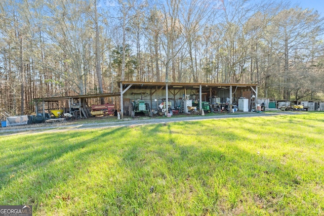 back of property with a yard and an outdoor structure