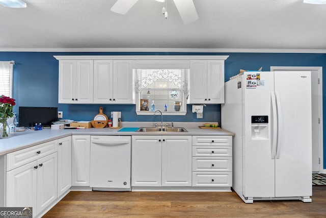 kitchen featuring sink, white appliances, white cabinetry, and crown molding