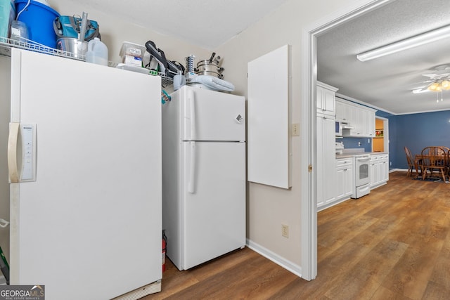 kitchen with white cabinetry, dark wood-type flooring, white appliances, and a textured ceiling