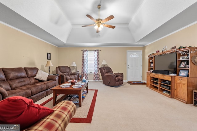 carpeted living room featuring ceiling fan, a tray ceiling, and crown molding