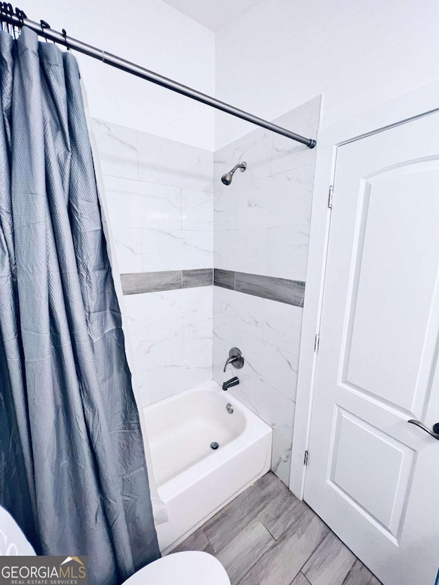 bathroom with toilet, hardwood / wood-style flooring, and shower / bathtub combination with curtain