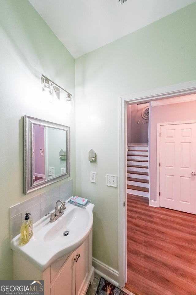 bathroom with decorative backsplash, vanity, and hardwood / wood-style floors