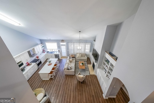 living room featuring a notable chandelier and dark hardwood / wood-style flooring