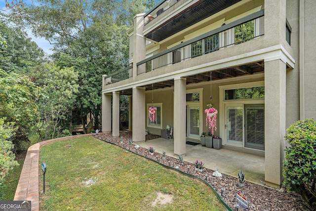 back of house with a patio area and a lawn