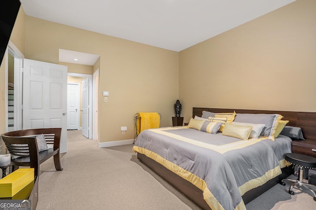 bedroom with baseboards and light carpet