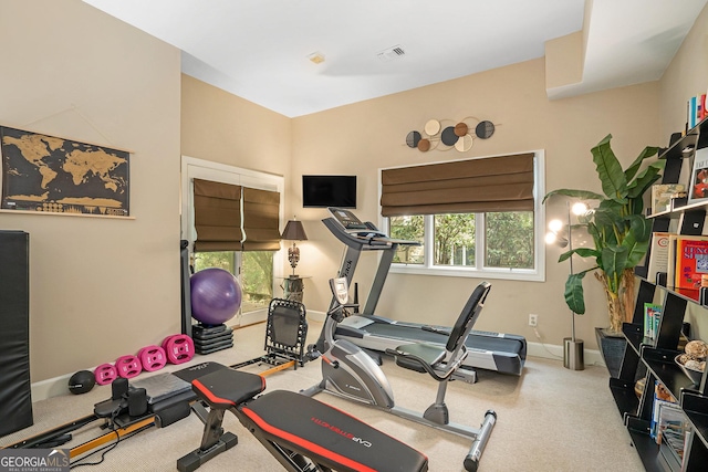 exercise area with visible vents, baseboards, and carpet floors