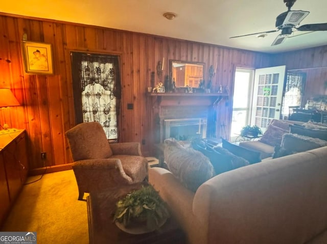 carpeted living room with wood walls and ceiling fan