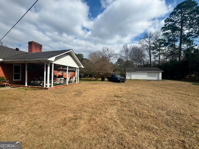 view of yard with a garage and an outbuilding