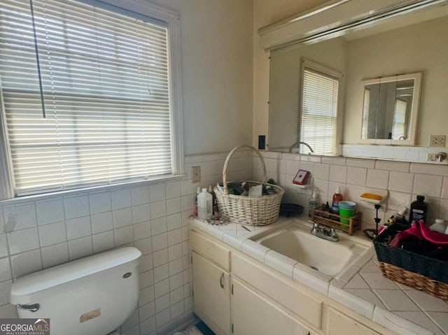 bathroom featuring tile walls, vanity, and toilet