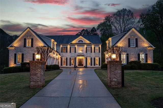 view of front of house with driveway and a yard