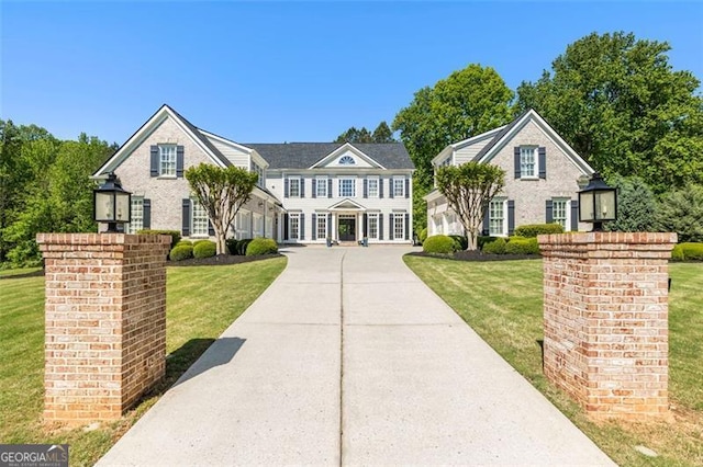 view of front facade with a front lawn and concrete driveway