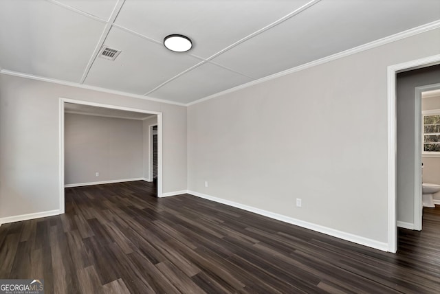 unfurnished bedroom featuring dark wood-type flooring, visible vents, crown molding, and baseboards