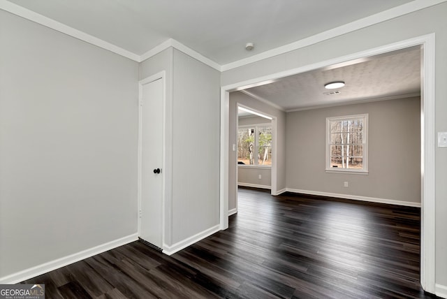 unfurnished room featuring baseboards, dark wood-style flooring, and crown molding