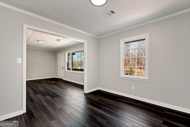 spare room featuring visible vents, baseboards, dark wood finished floors, and crown molding