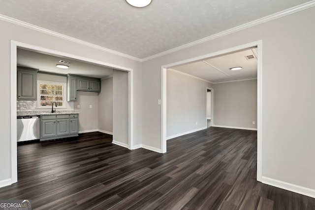 unfurnished dining area with ornamental molding, dark wood finished floors, a sink, and baseboards