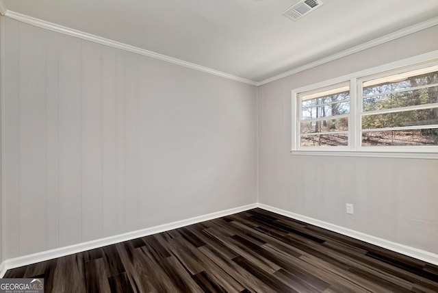 spare room featuring dark wood-style floors, baseboards, visible vents, and ornamental molding