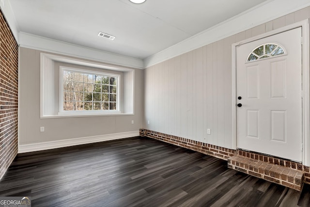 entrance foyer featuring visible vents, dark wood-type flooring, a wealth of natural light, and ornamental molding