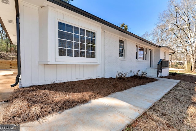 view of property exterior with brick siding and crawl space