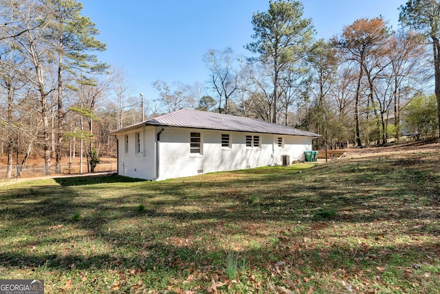 exterior space featuring crawl space, a yard, metal roof, and brick siding