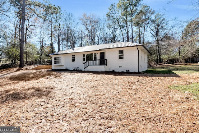 ranch-style home featuring metal roof, brick siding, and crawl space