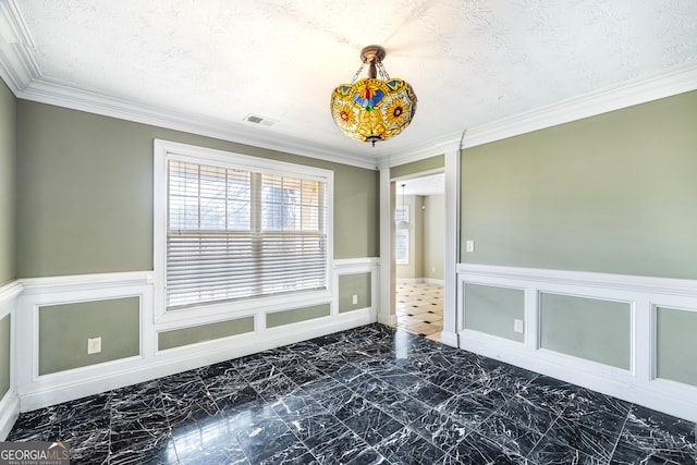 empty room featuring ornamental molding and a textured ceiling