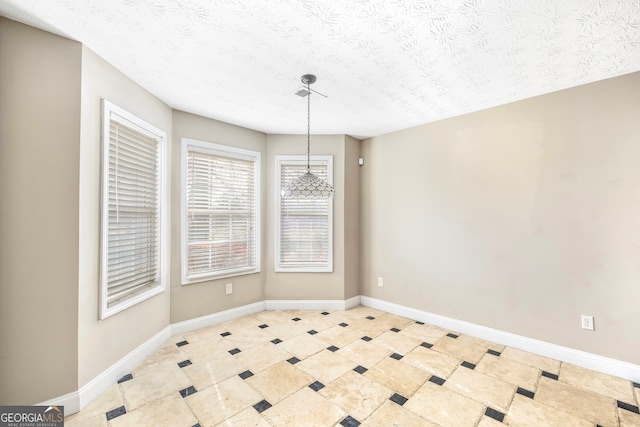 unfurnished dining area featuring a textured ceiling