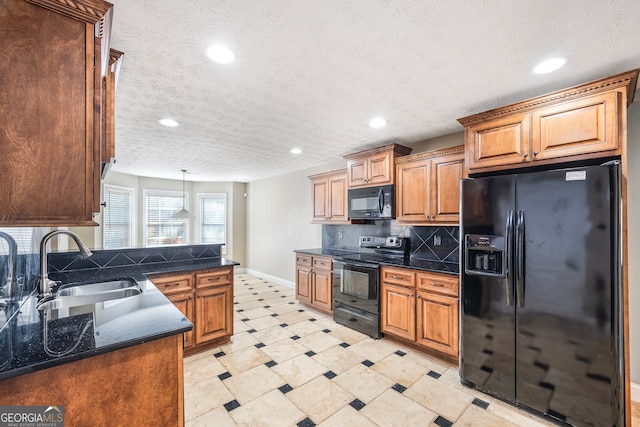 kitchen with a textured ceiling, black appliances, decorative light fixtures, backsplash, and sink