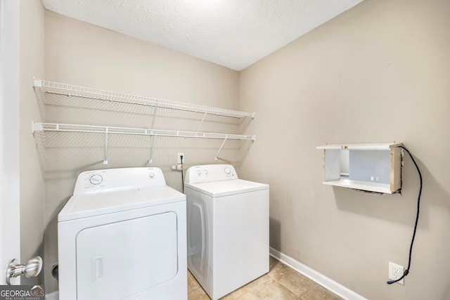 washroom with washer and clothes dryer and a textured ceiling