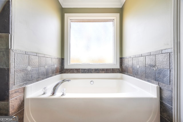 bathroom featuring tile walls, ornamental molding, a tub to relax in, and a healthy amount of sunlight