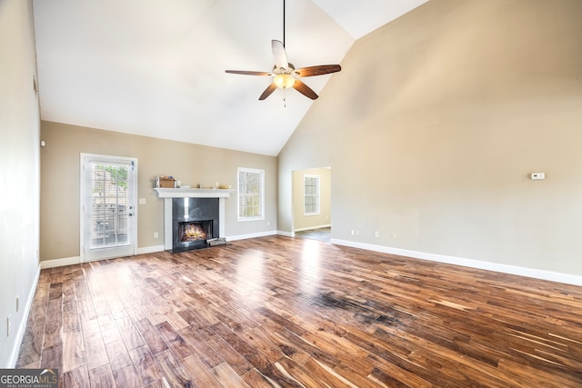 unfurnished living room with hardwood / wood-style flooring, high vaulted ceiling, ceiling fan, and a premium fireplace