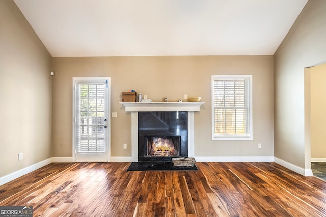 unfurnished living room with a premium fireplace, wood-type flooring, and lofted ceiling