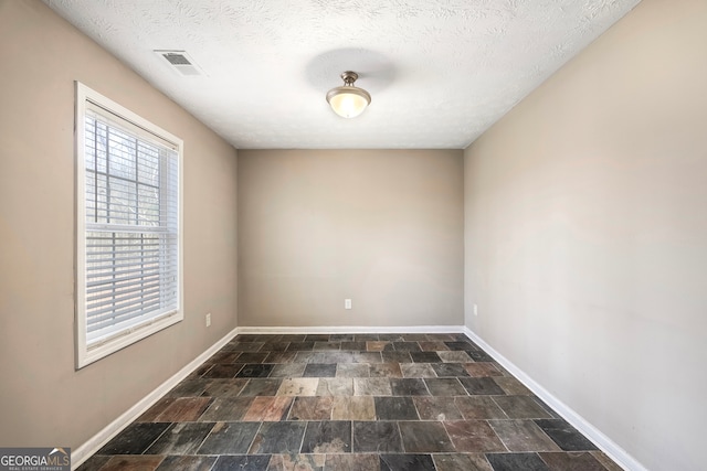 spare room featuring a textured ceiling